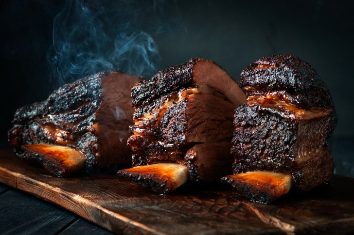 Cut a large piece of smoked beef brisket to the ribs with a dark crust.