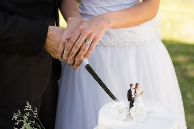 Extreme close-up mid section of a newlywed cutting wedding cake