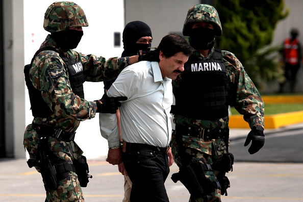 Mexican Navy soldiers escort Joaquin Guzman Loera (front), alias "El Chapo Guzman", leader of the Sinaloa Cartel, during his show up in front of the press, at the Mexican Navy hangar in Mexico City, capital of Mexico, on Feb. 22, 2014. Mexican President Enrique Pena Nieto on Saturday confirmed the capture of the world's most wanted drug lord, Joaquin Guzman Loera, known as El Chapo, in the Pacific resort of Mazatlan. (Photo by Jair Cabrera Torres/NurPhoto) (Photo by NurPhoto/Corbis via Getty Images)