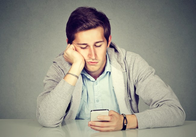 Bored man using his smart phone