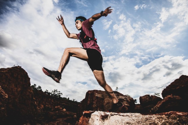 trail runner jumping rocks