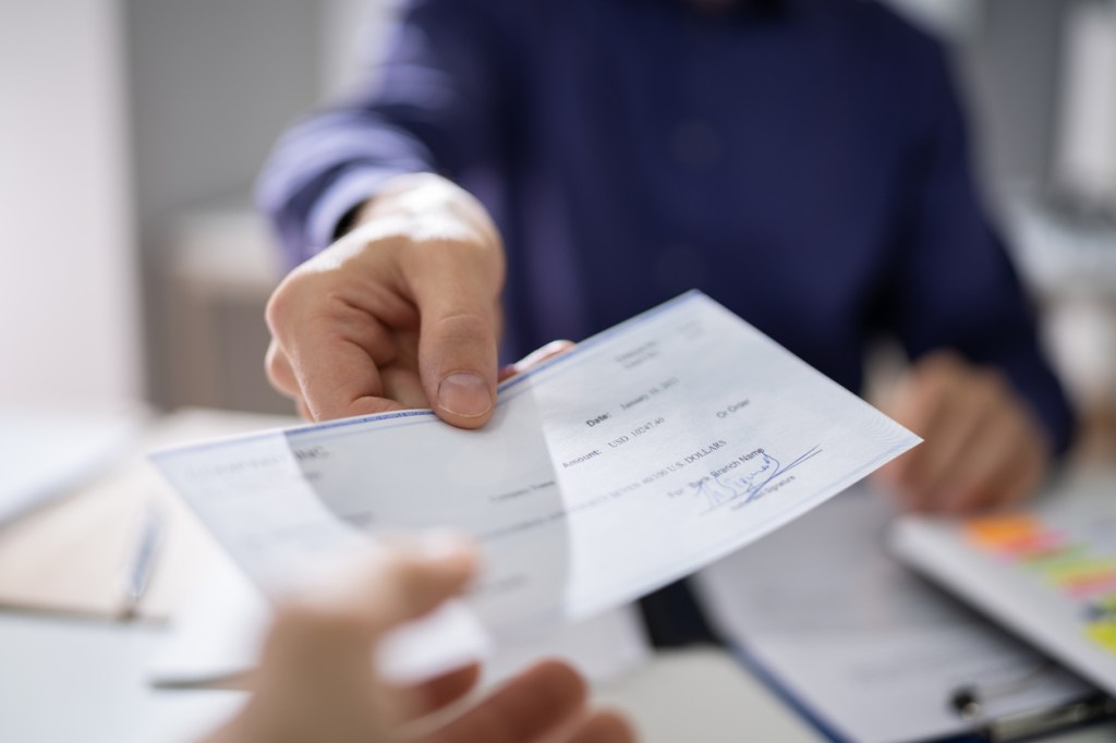 person handing paycheck