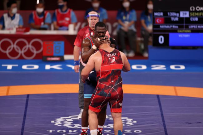 CHIBA, JAPAN - AUGUST 01: Riza Kayaalp (red) of Team Turkey and Mijain Lopez Nunez (blue) of Team Cuba hug each other after competing in menâs wrestling greco-roman semi final match during Tokyo 2020 Olympic Games at Makuhari Messe Hall in Chiba, Japan on August 01, 2021. 
