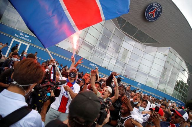 Supporters cheer outside French football club Paris Saint-Germain's (PSG) Parc des Princes stadium in Paris on August 10, 2021, after Argentinian football player Lionel Messi landed in Le Bourget airport near Paris. - Asked by reporters at Barcelona's El Prat airport if the Argentine star would later on sign with the French club, Jorge Messi, the father and player's agent, said: "Yes".