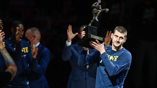 nikola jokic holding up his MVP award