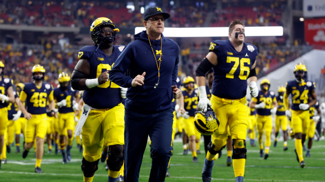 Jim Harbaugh runs on the field.
