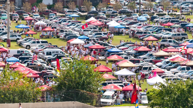 Football fans tailgate outside the stadium.