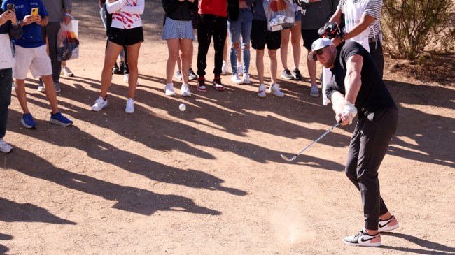 JJ Watt hits a golf shot from the bunker.