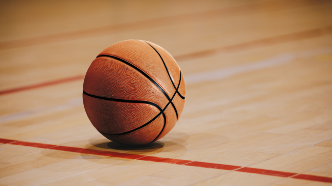 A basketball rests on the court.