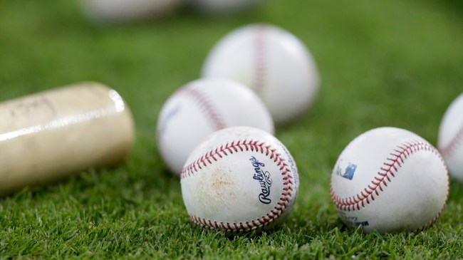 MLB baseballs next to a bat