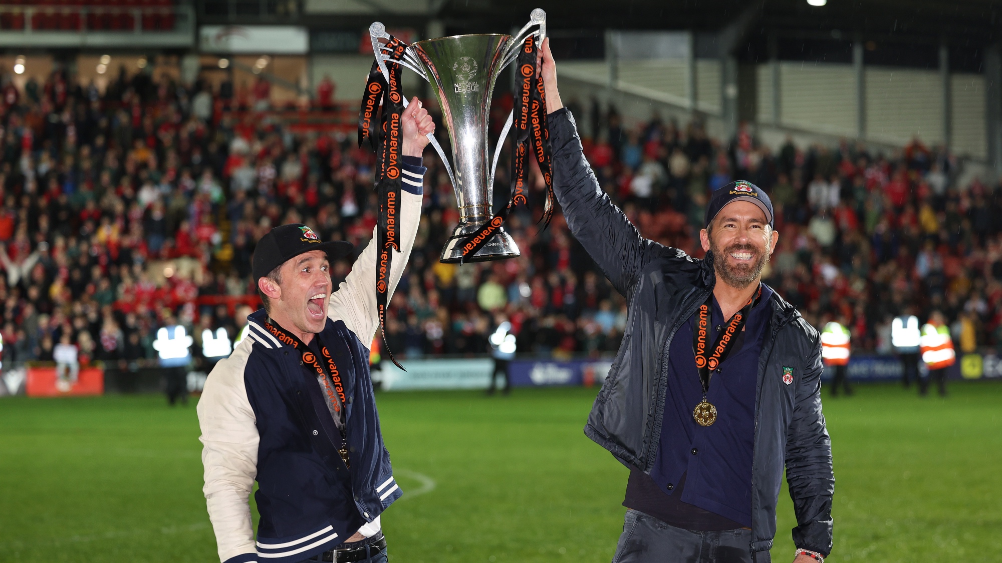 Wrexham AFC owners holding trophy Ryan Reynolds and Rob McElhenney