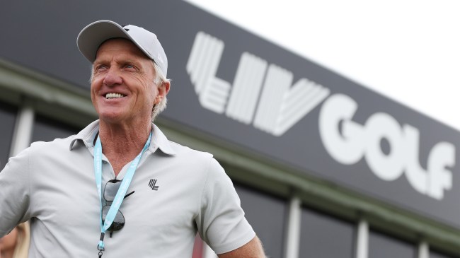 Greg Norman standing in front of LIV Golf logo