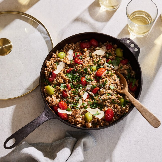A Smithey Cast Iron skillet filled with a rice dish and a glass of wine on the side