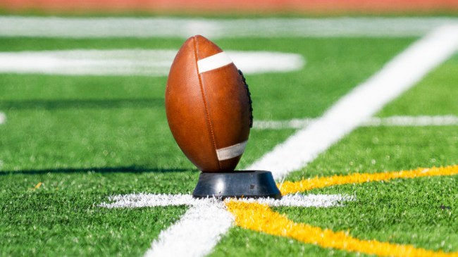 A football sits on a kicking tee.