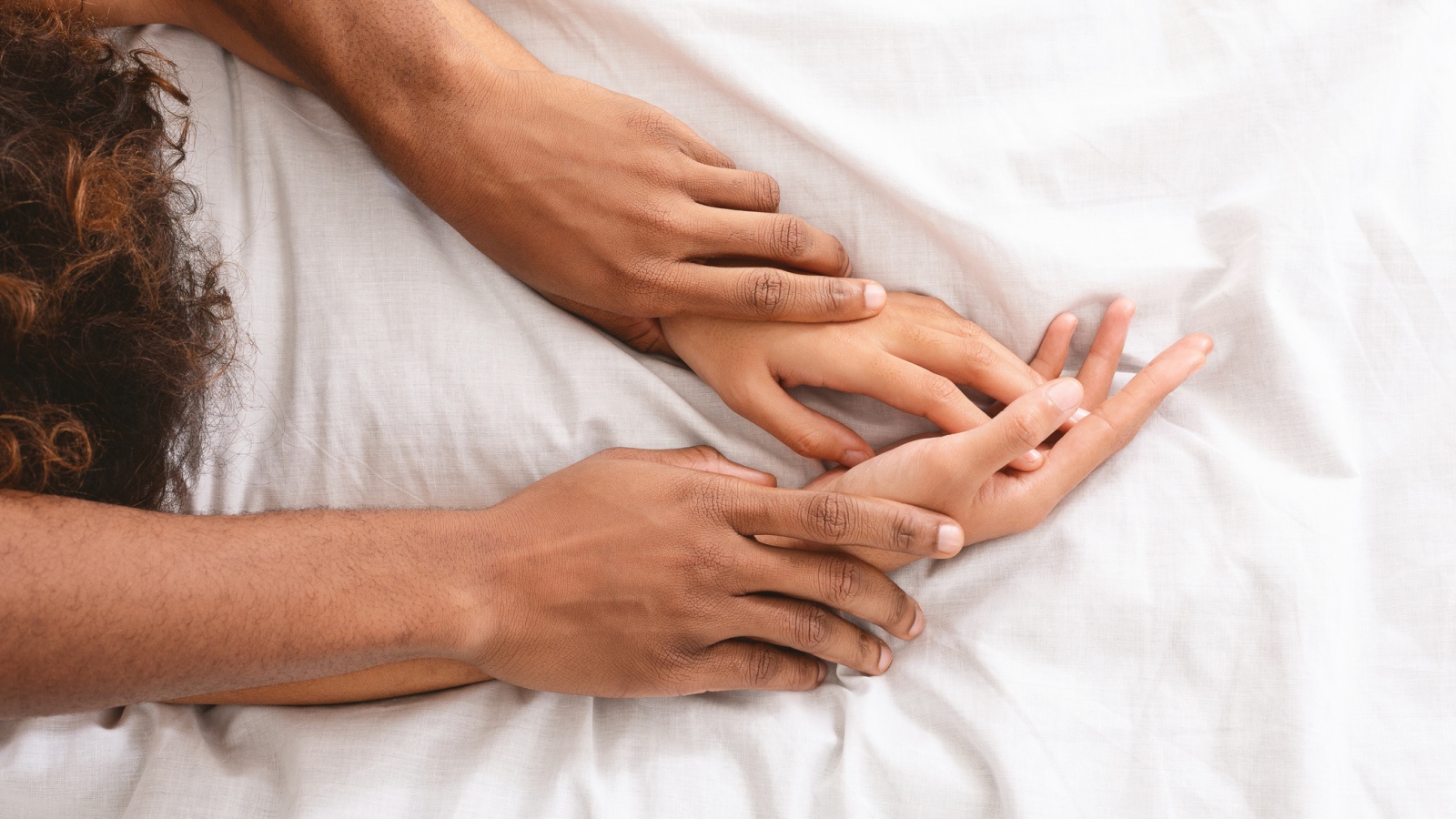 couple holding hands in bed