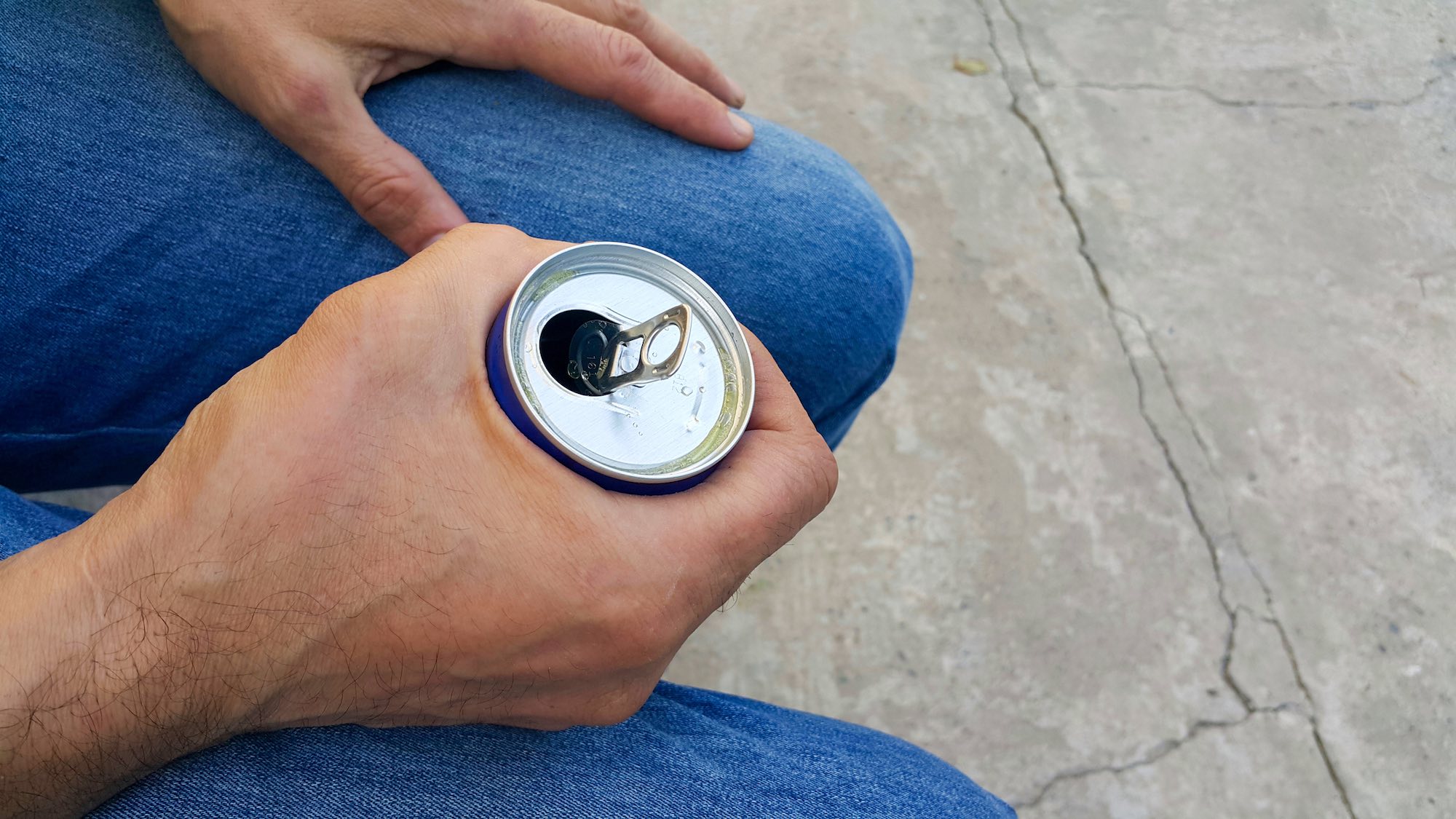 A man holds an aluminum energy drink can
