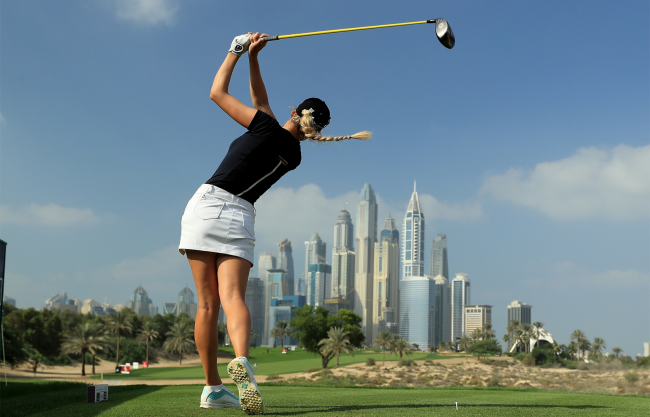 paige spiranac hits a drive on golf course