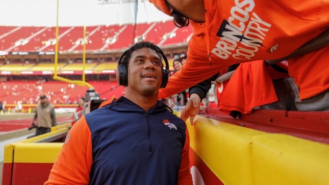 Russell Wilson takes a photo with a fan.