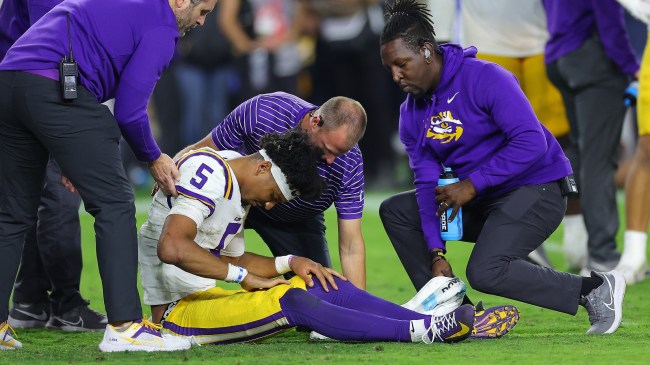 Jayden Daniels is slow to get up after taking a hit from Alabama defender Dallas Turner.