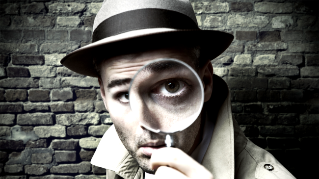 private investigator looking through a magnifying glass