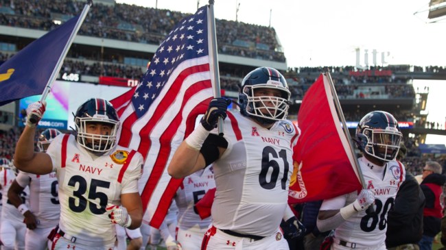 The Navy football team runs onto the field before a game against Army.
