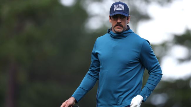 aaron rodgers playing golf in a usa flag hat