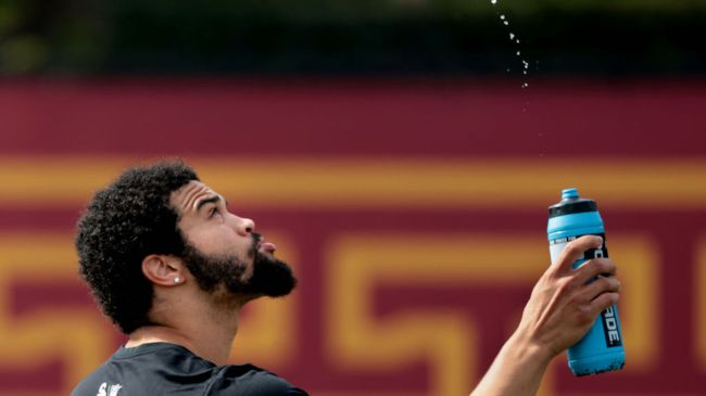 caleb williams spraying water in the air