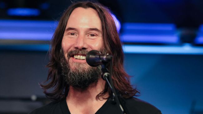 keanu reeves speaking into a microphone