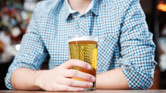 man in a collared shirt holding a beer