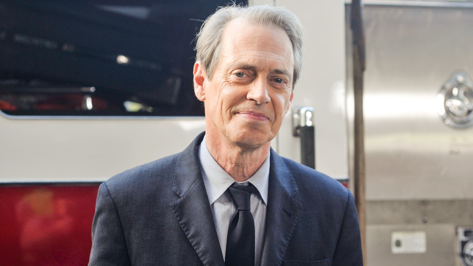 actor Steve Buscemi posing in front of an FDNY fire engine