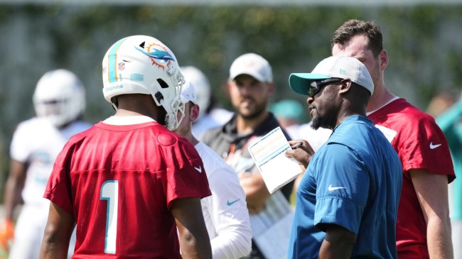 Brian Flores speaks to Tua Tagovailoa during practice.
