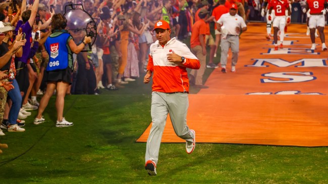 Clemson football coach Dabo Swinney runs onto the field.