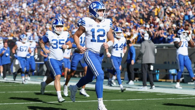 The BYU football team runs onto the field