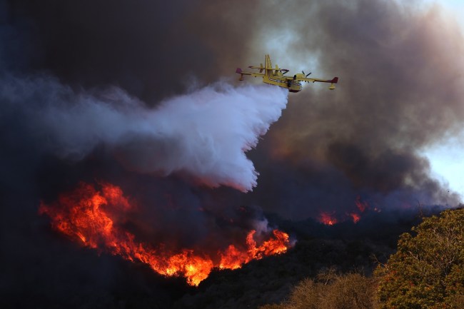 A firefighting plane makes a drop on the Palisades fire in Pacific Palisades on Tuesday, Jan. 7. The Palisades fire is bein