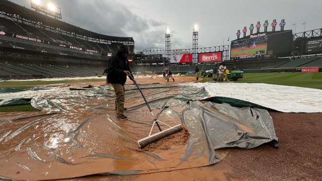 White Sox grounds crew worker mops water off tarp during rain delay