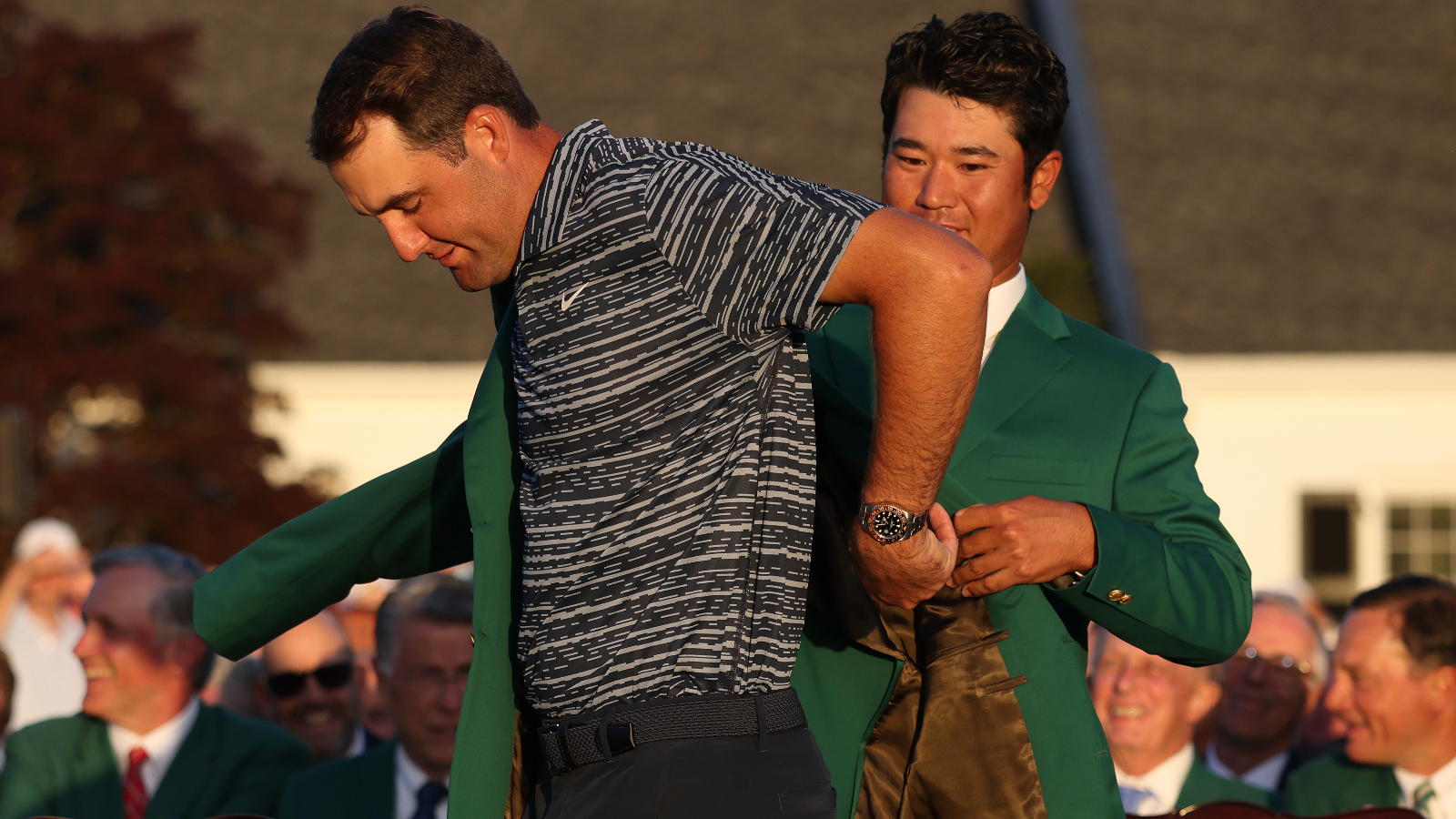 Scottie Scheffler wearing a Rolex watch putting on a green jacket