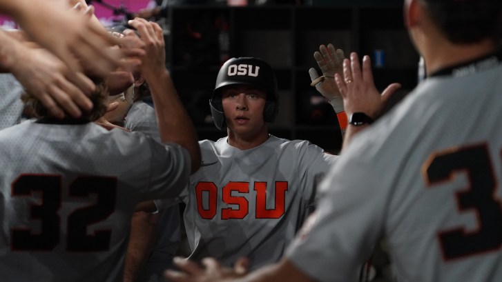 Oregon State baseball players celebrate in the dugout