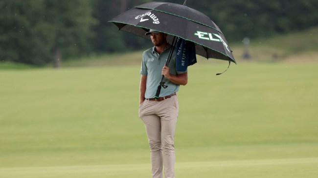 Sam Burns holds an umbrella at the US Open